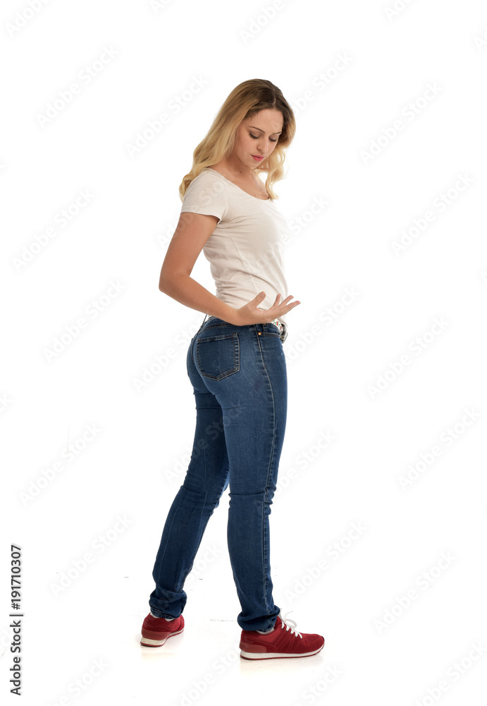 full length portrait of blonde girl wearing simple shirt and jeans, standing pose on white background. full length portrait of blonde girl wearing simple shirt and jeans, standing pose on white background.