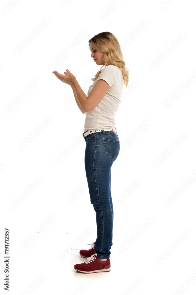 full length portrait of blonde girl wearing simple shirt and jeans, standing pose on white background. full length portrait of blonde girl wearing simple shirt and jeans, standing pose on white background.