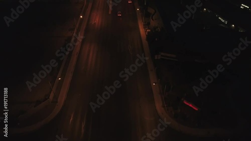 Aerial establishing shot of large city with lights at night tilting