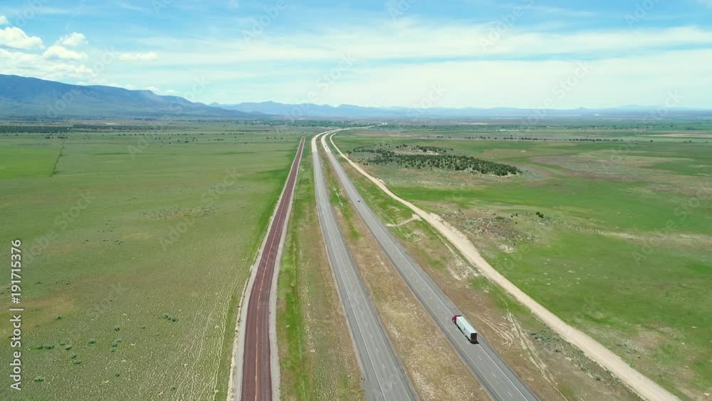 Aerial high shot of fast cars moving along a highway in spring Aerial high shot of fast cars moving along a highway in spring