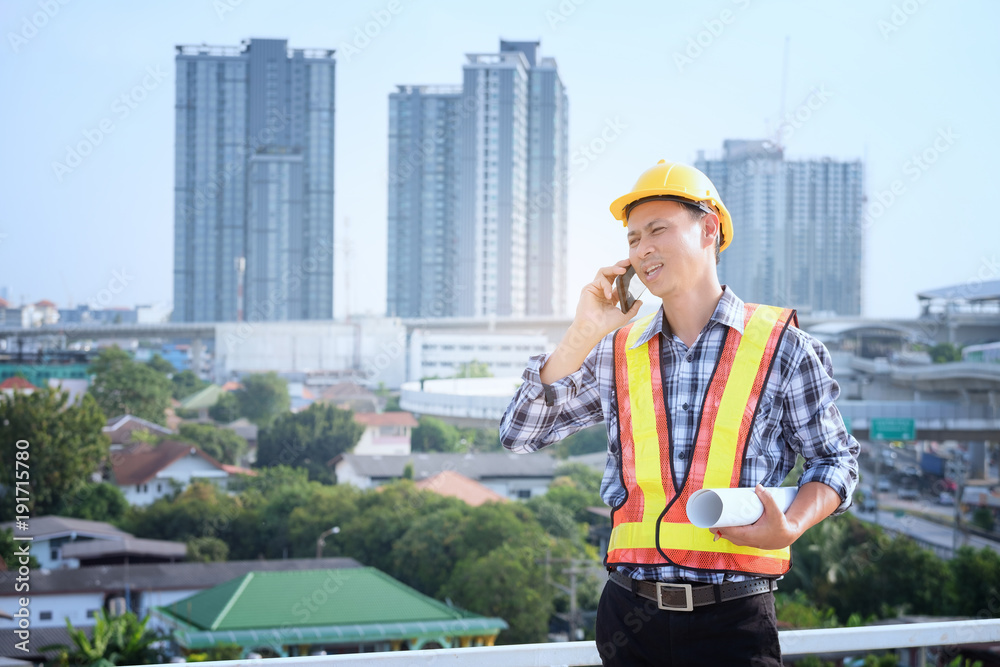 Man Engineers stand on tall buildings and talk about cell phones in the ...