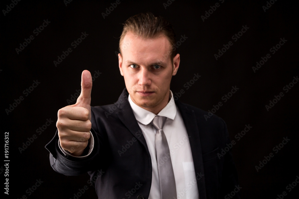 Businessman with thumb up on black background Businessman with thumb up on black background