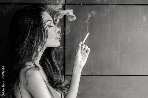 Fashion portrait of beautiful woman sexy slim body smoking cigarette