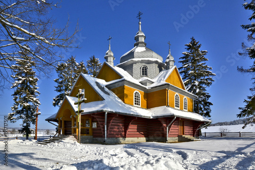 Wooden  church in winter sunny day, Gladyszow, Beskid Niski, Poland photo