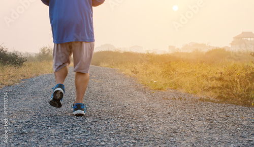 Sports and healthy lifestyle concept:a fat man running during a foggy sunrise in the countryside