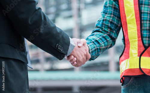 Businessman shaking hands engineer, Greeting Deal Concept, modern city background. © nattanan