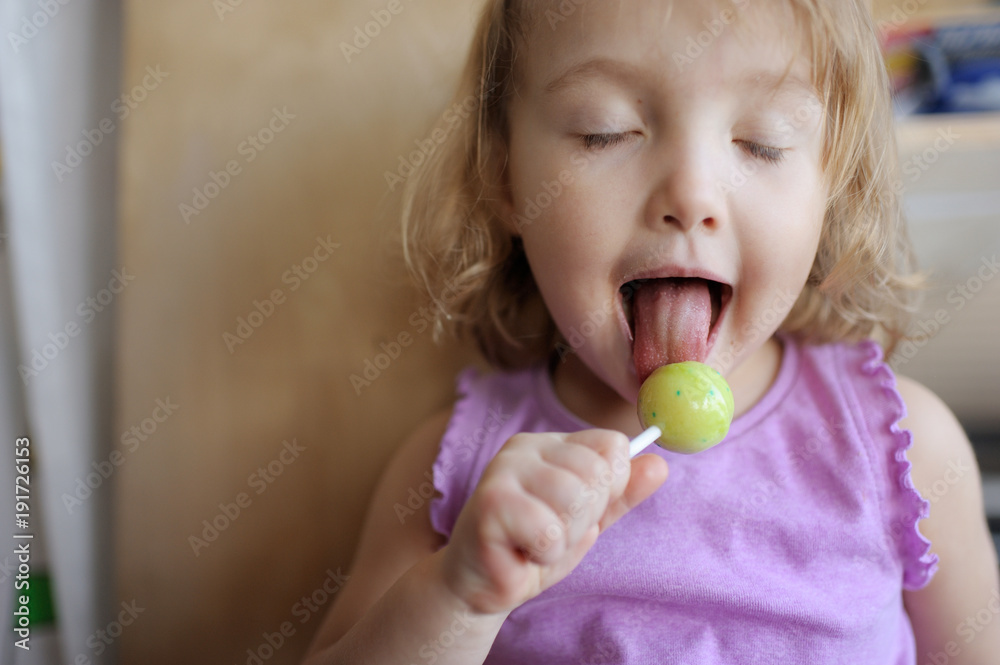 The girl eats big lollipop. The girl licks candy The girl eats big lollipop. The girl licks candy