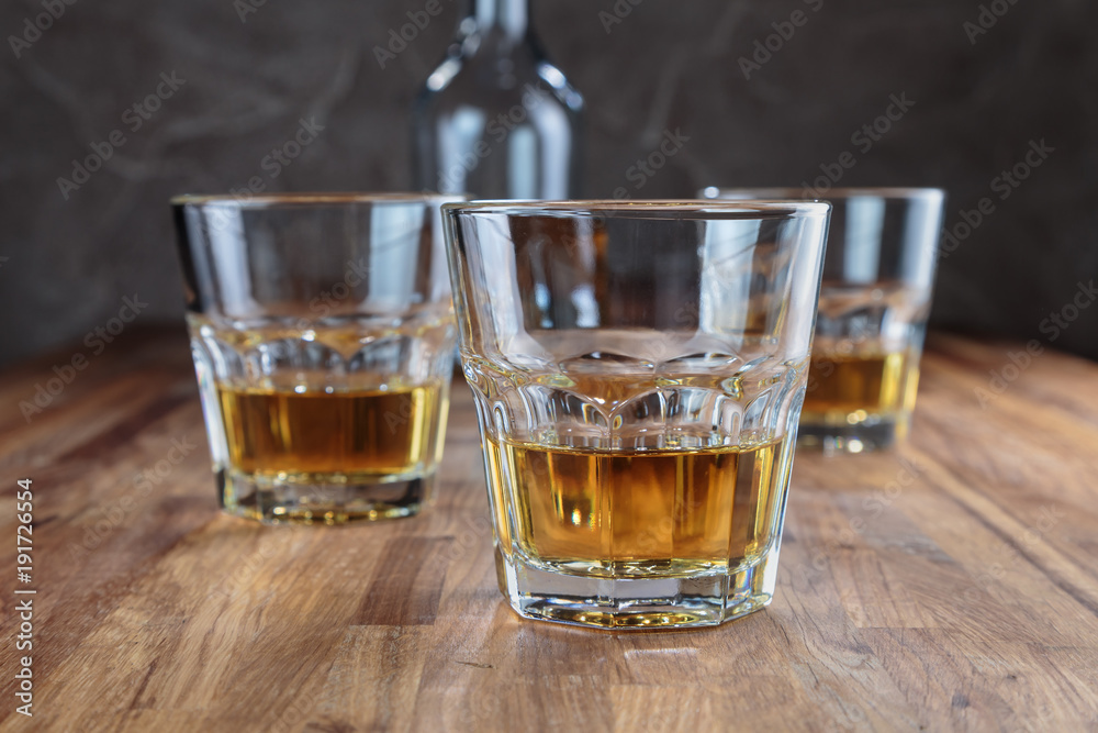 three glasses of whiskey on the oak surface of the table three glasses of whiskey on the oak surface of the table