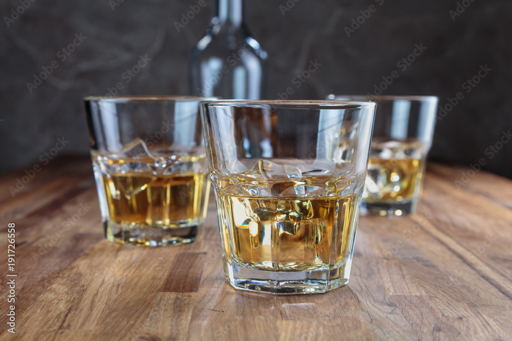 three glasses of whiskey on the oak surface of the table three glasses of whiskey on the oak surface of the table
