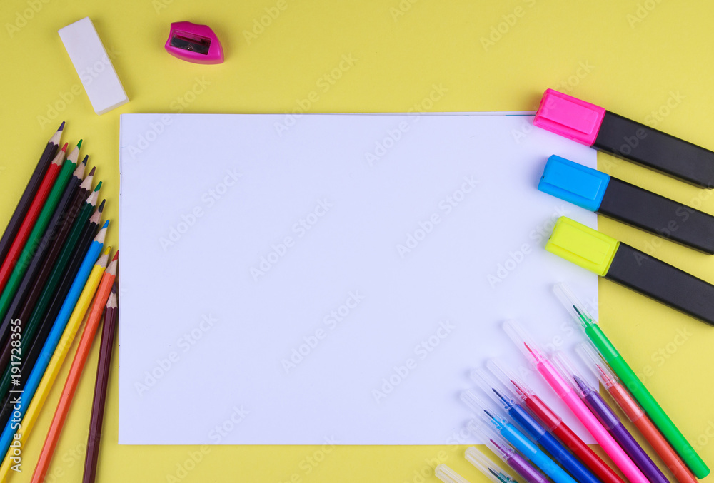 White sheet of paper on a yellow background with copy space and place to inscribe around a color pen ink painters, brushes and pencils copy space. Brash is paint a red color paint. top view White sheet of paper on a yellow background with copy space and place to inscribe around a color pen ink painters, brushes and pencils copy space. Brash is paint a red color paint. top view