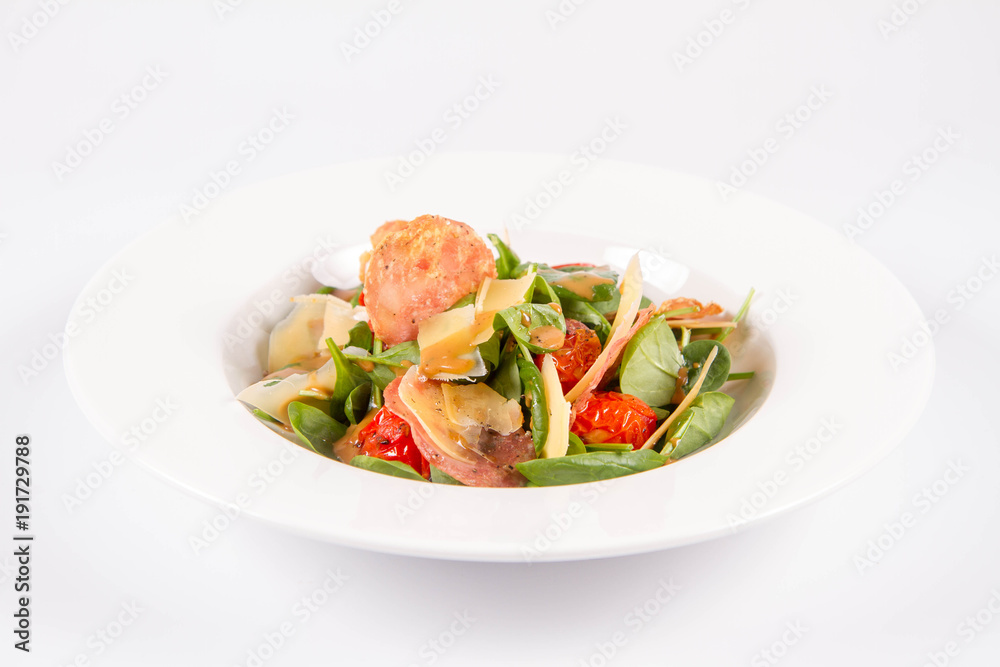 Baby spinach, dry sausage, matured cheese, roast tomatoes, thyme-balsamic vinaigrette salad on a white background Baby spinach, dry sausage, matured cheese, roast tomatoes, thyme-balsamic vinaigrette salad on a white background