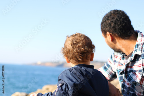 Father and son looking at the landscape of a cliff © tiagozr
