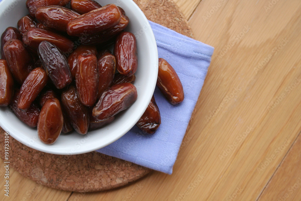 Bowl of dried dates on wooden background
Bowl of dried dates on wooden background