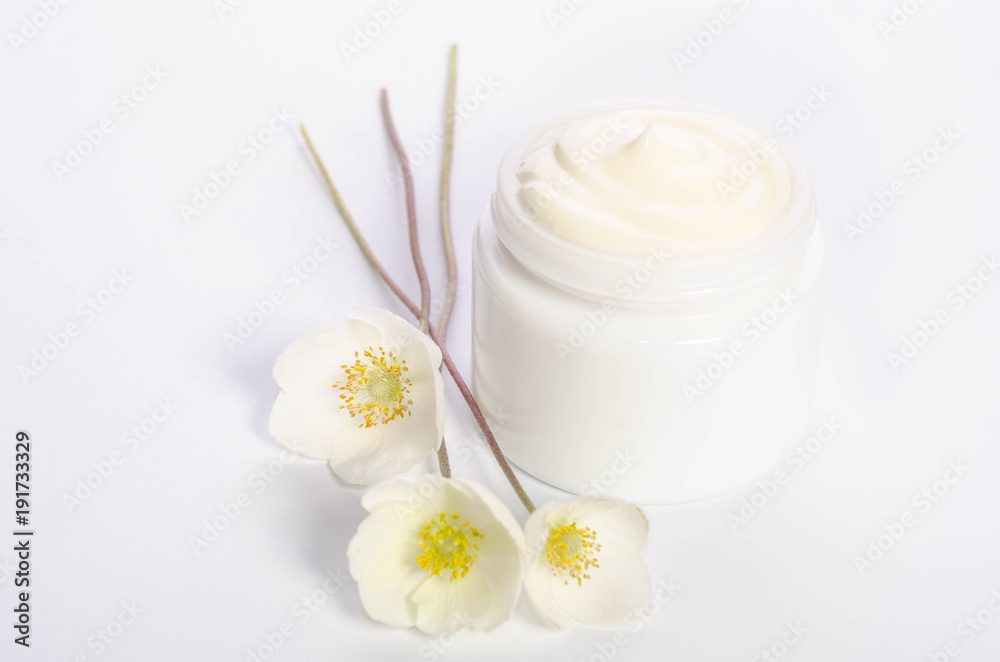 Cute flowers  and a jar of natural body cream isolated on white background