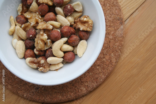 Mixed nuts in a bowl on wooden background 