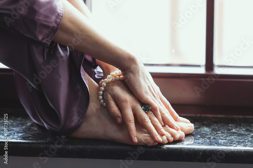 Bare feet of woman stand on granite window sill © glebchik