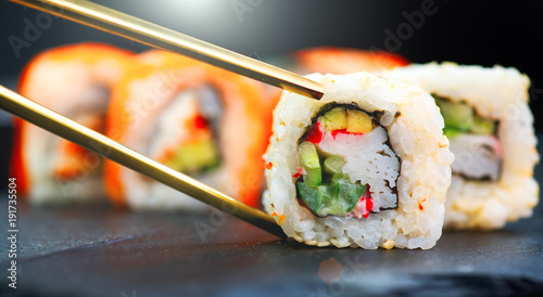 Sushi rolls. Japanese food in restaurant. Sushi roll set california with salmon, vegetables, flying fish roe and caviar closeup