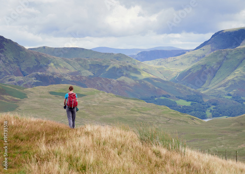 A female hiker walking off the summit of Great Borne towards Loweswater Fell in the English Lake District, UK. © Duncan Andison