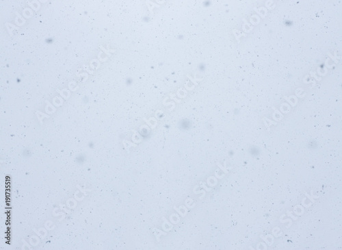 Snowfall. Abstract winter blurred background with flying snow flakes.