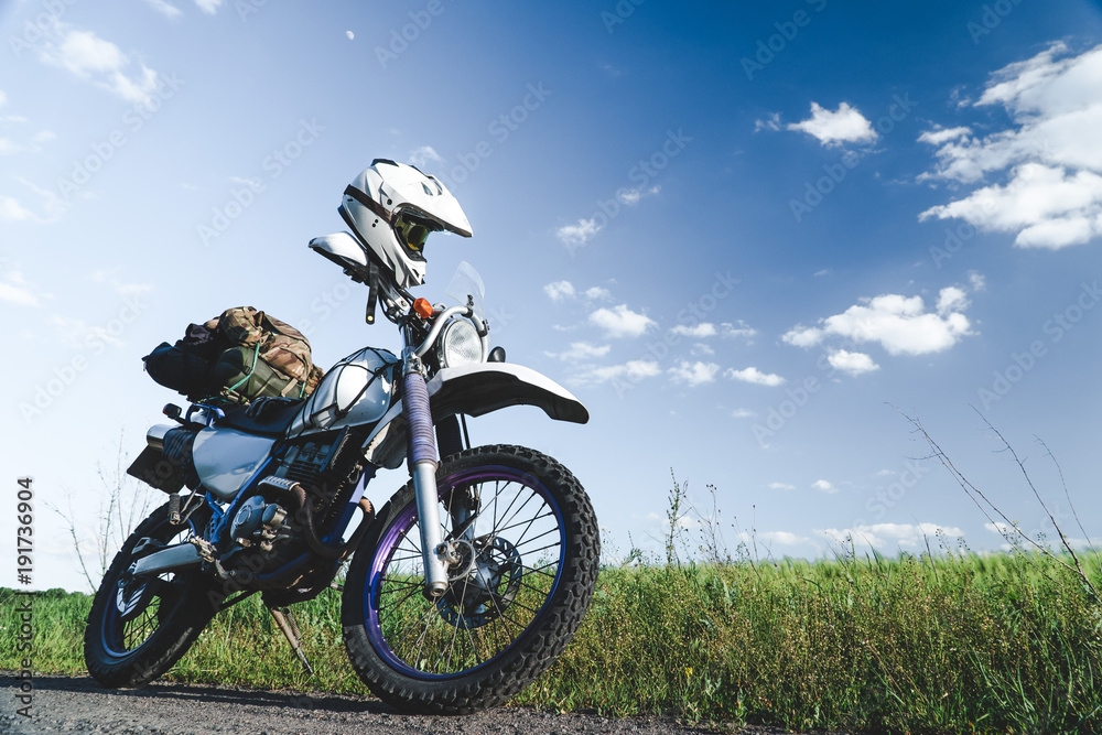 off road dual sport enduro motorcycle on the road between rice fields at sunset, travel concept design off road dual sport enduro motorcycle on the road between rice fields at sunset, travel concept design