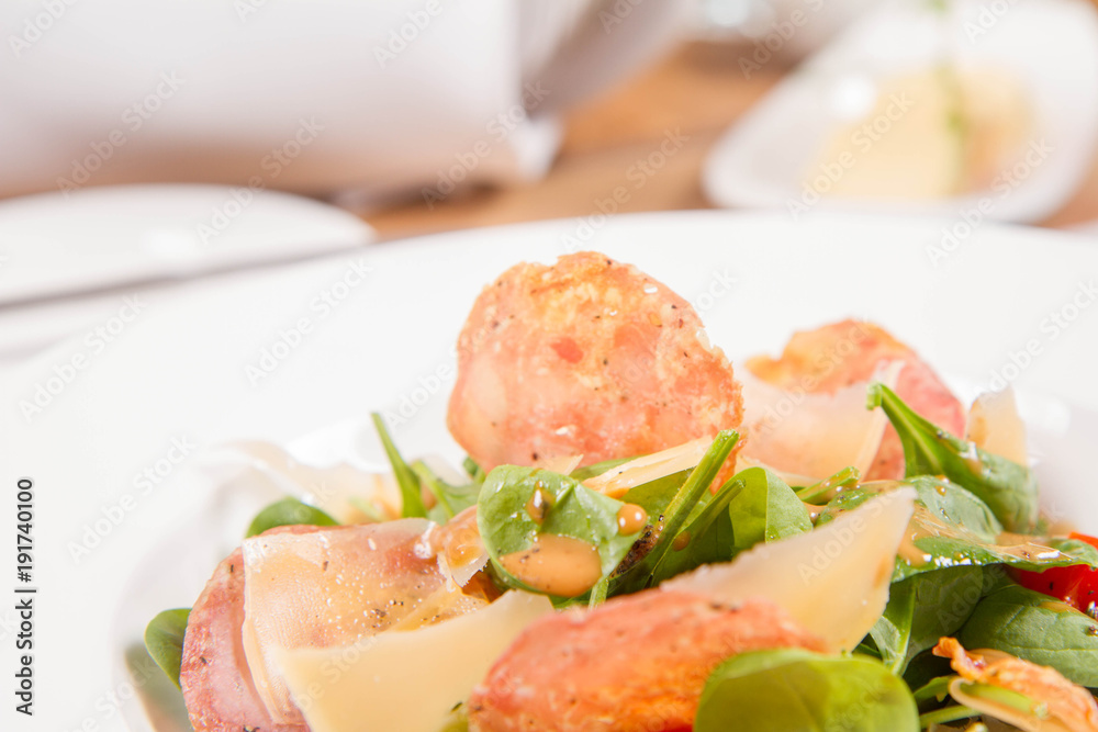 Baby spinach, dry sausage, matured cheese, roast tomatoes, thyme-balsamic vinaigrette salad served in a restaurant Baby spinach, dry sausage, matured cheese, roast tomatoes, thyme-balsamic vinaigrette salad served in a restaurant