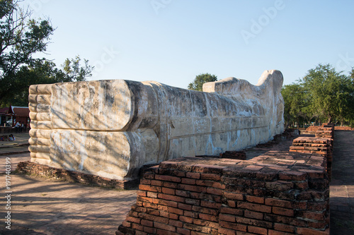 Ayutthaya, Thailand - January 1, 2018: big reclining buddha statue at Wat Lokayasutharam or Wat pranon . many people going to oblation and pray photo