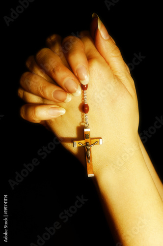 prayer hands with Christian Catholic cross with rosary - cross and Christ - like a religion concept 