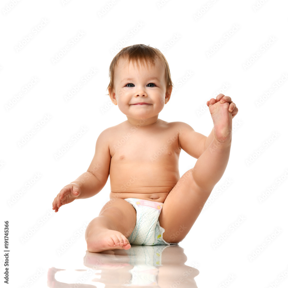 Beautiful infant baby girl toddler sitting in diaper and hold one leg Beautiful infant baby girl toddler sitting in diaper and hold one leg