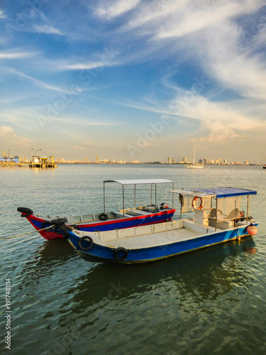 Speed boats at the Clan Jetties of Georgetown with a city view and a dramatic blue sky in the background - Penang  Malaysia