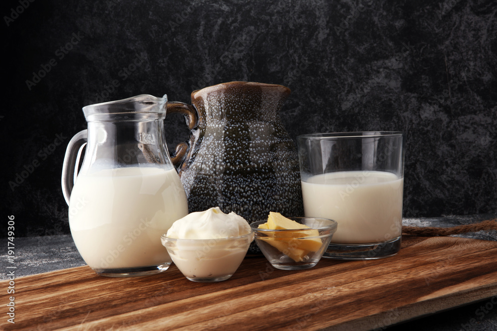 milk products - tasty healthy dairy products on a table sour cream in a bowl, cream and milk jar