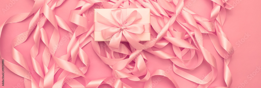 Banner Boxes with gifts on the background of a Coil of decorative satin ribbons of pink color.