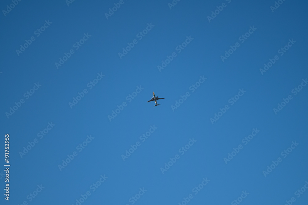 Plane is flying on a blue sky.
