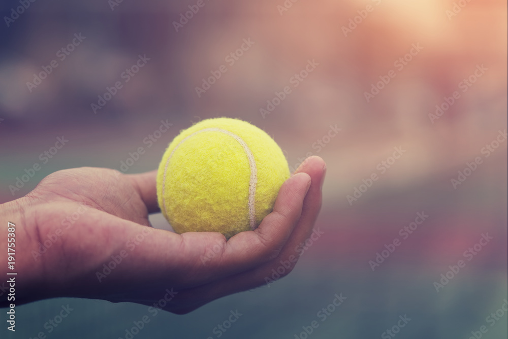 Tennis player holding the ball and getting ready to serve.