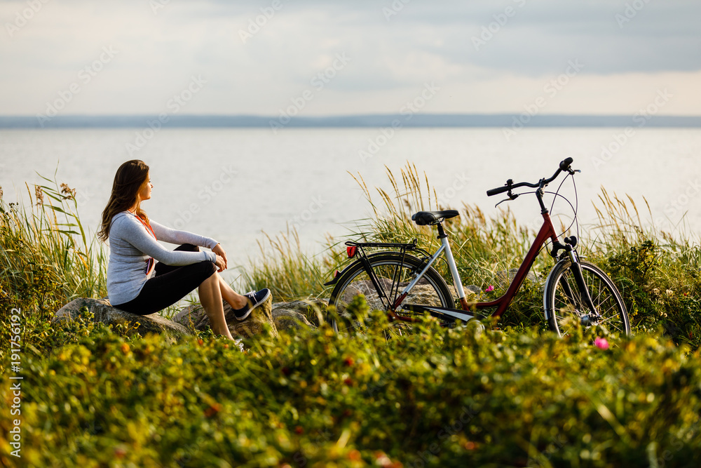 Fototapeta premium Young woman with bike at seaside