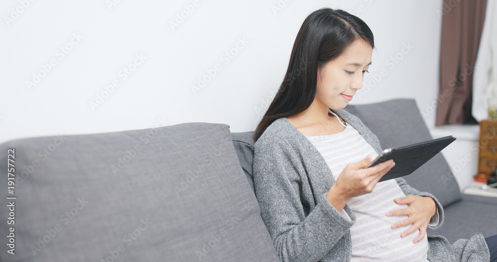 Pregnant woman using tablet computer at home Pregnant woman using tablet computer at home