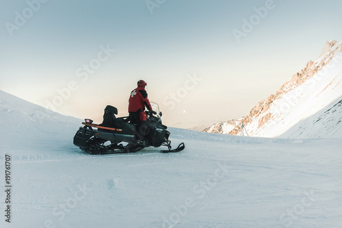 Foto Man lifeguard snowmobile rides in the mountains.