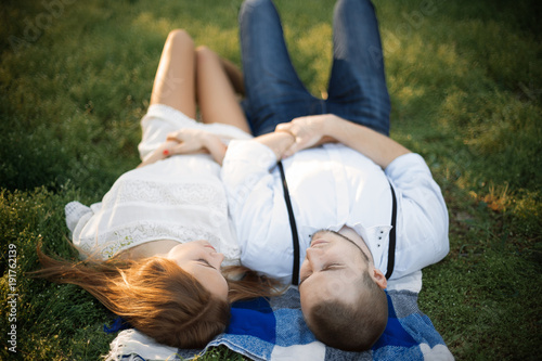 Young couple in love on a picnic. Happy man and woman on the lawn in the park.