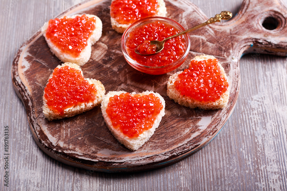 Red caviar over heart shape bread Red caviar over heart shape bread