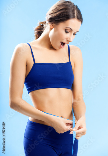 Woman in fitness wear with tape, over blue © vgstudio