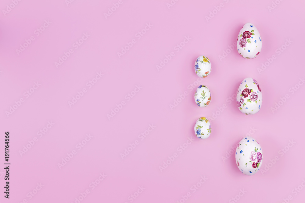 Happy Easter concept. Big and small easter eggs with spring's flower pattern on pink background