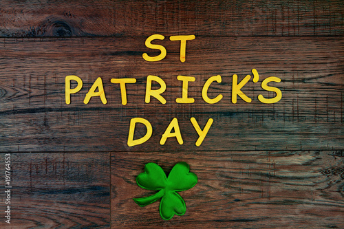 Saint Patrick's Day. Wooden letters "St Patrick's Day" lying on wooden background with green three petal clover