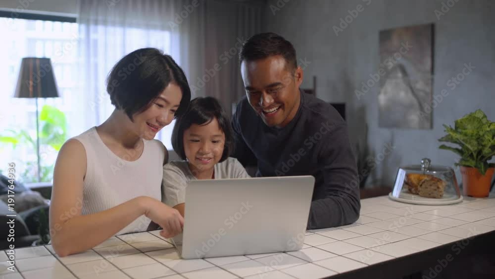 Happy Asian family using the computer together at home. Happy Asian family using the computer together at home.