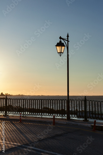 Street lamppost illuminated by setting sunlight