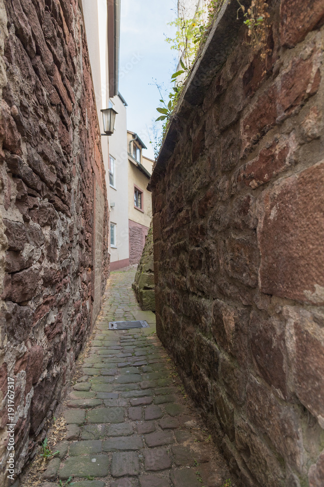 Enge Gasse mit Steinmauer in einer deutschen Altstadt
