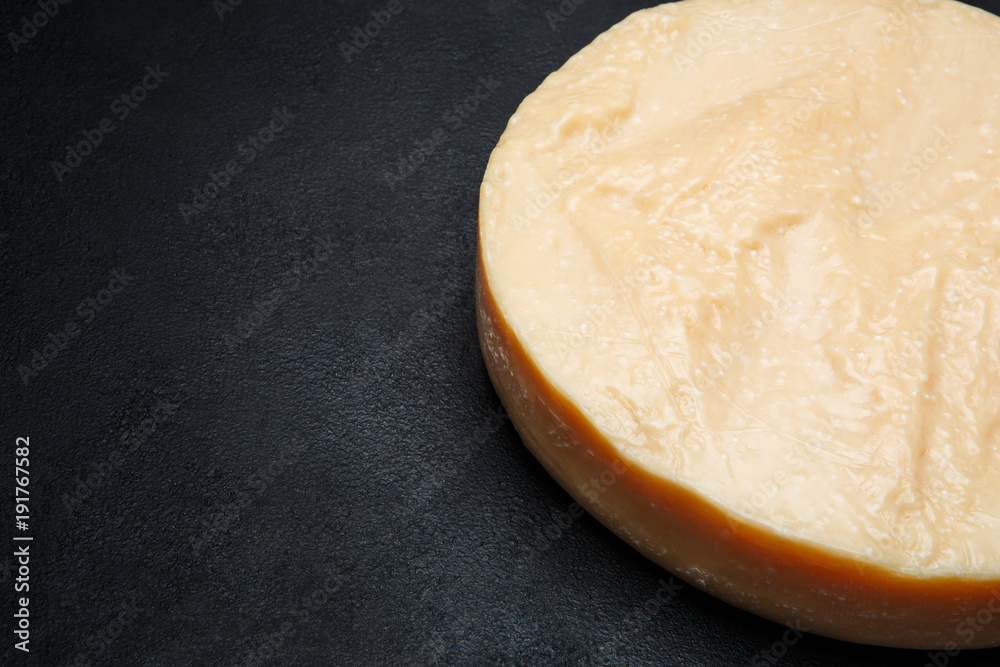 Whole round Head of parmesan or parmigiano hard cheese on concrete background Whole round Head of parmesan or parmigiano hard cheese on concrete background