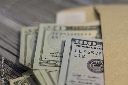 United States money in an envelope on the table. Rough boards background. Money concept. Closeup