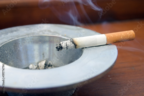 Burning cigarette smoking on an ashtray