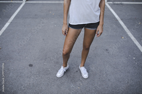 Female standing at asphalt sport field