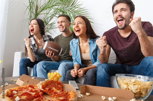 Group of friends sport fans watching rugby match victory