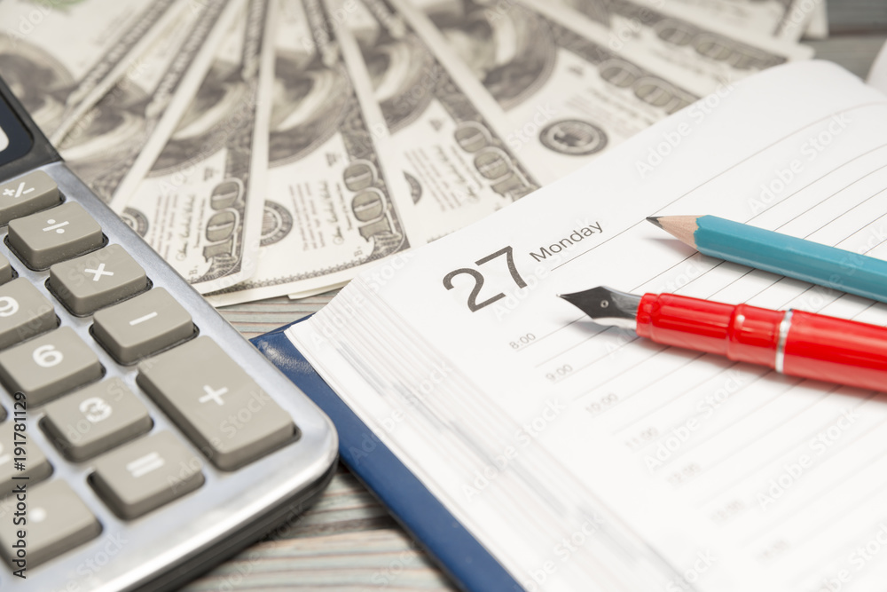 diary, pencil. pen on the background of dollars, calculator. business planning. finance. diary, pencil. pen on the background of dollars, calculator. business planning. finance.